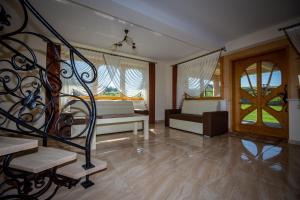 a living room with a staircase and a bedroom at Podhalanski Dworek SPA in Białka Tatrzańska