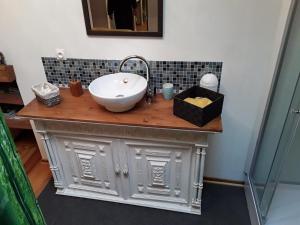 a bathroom counter with a sink and a mirror at Chambre Sergeanne in Doulezon