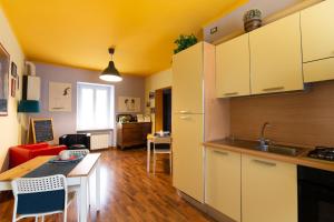 a kitchen with white cabinets and a table in a room at Camaga in LʼAquila