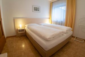 a bedroom with a large bed with a window at App. Tamanhof in San Giorgio