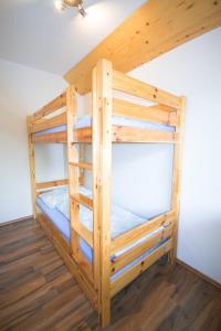 a bunk bed in a room with wooden floors at Ferienwohnung Plattner in Schmirn