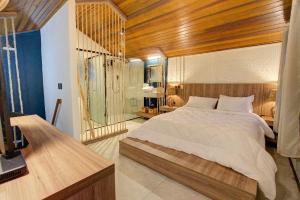 um quarto com uma cama grande e um tecto em madeira em Malie Chalés na Ilha do Mel
