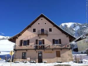 a large house with a balcony in the snow at appartement gentiane 5personnes dans gite "la maison d'augustin" classé 2 étoiles,la tour,73530 st jean d'arves in Saint-Jean-dʼArves