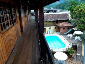 an outdoor balcony with a swimming pool on a building at Hotel Montanus in Nova Friburgo