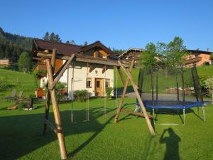 a swing set in the yard of a house at Ferienhaus & -wohnung Flatscher in Waidring