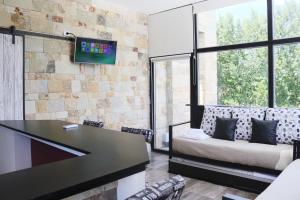 Habitación con mesa, sofá y TV. en Limay Bed&Breakfast en Neuquén