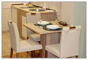 a kitchen with a table with two chairs and a dining room at Apartment Libra in Novi Sad