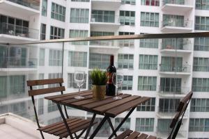 a table with a bottle of wine and two glasses at ✦Time & Traveller✦Regalia Suites and Residence✦KLCC view Infinity Pool✦双子塔无边泳池 in Kuala Lumpur