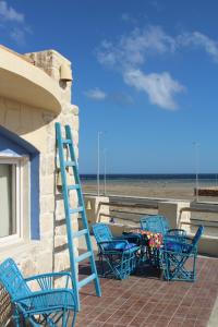 een groep blauwe stoelen en een tafel en een ladder bij Light House in Marsa Alam