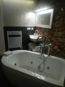 a bathroom with a bath tub and a sink at Casa O Gures in Serantes
