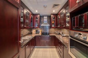 a large kitchen with wooden cabinets and a sink at bnbmehomes Elegant Escape Downtown Opp to Burj - 504 in Dubai