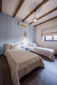 Casa di vitalo في Kampíon: غرفة نوم بسريرين ومغسلة