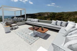 un patio con divano, tavolo e sedie. di 360ᵒ Luxury View Collection - Adults Only a Limenaria