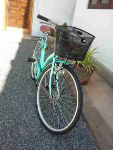 ein blaues Fahrrad mit einem Korb neben einem Haus in der Unterkunft JMF Hotel in Negombo