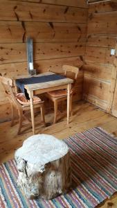 a wooden room with a table and chairs and a tree stump at Tiny house with Fjordview! in Lauvstad