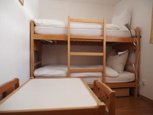 a room with two bunk beds and a table at Tgantieni Sot - Apartment mit Herz in Lenzerheide