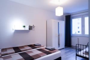 a bedroom with a bed with a checkered blanket at APARTAMENT FOCUS in Gdynia