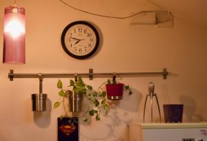 a clock hanging on a wall with potted plants at design loft in Cava deʼ Tirreni
