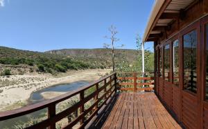 a porch of a cabin with a view of a beach at Gourits River Guest Farm in Albertinia