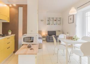 a kitchen and living room with a white table and chairs at Casa Paola in Perledo