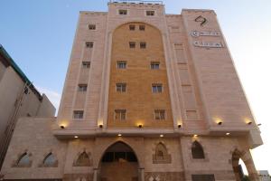 a building with a clock tower on top of it at Assilah Hotel in Al Madinah