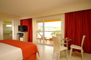 a bedroom with a bed and a table and a balcony at Arenas Blancas Cabañas & Suites in Nono +36 photos