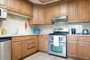 a kitchen with wooden cabinets and a stove top oven at Hostel Style Shared Room in Daly City