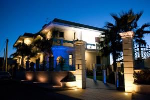 a white house with palm trees in front of it at Hotel San Paolo in Manduria