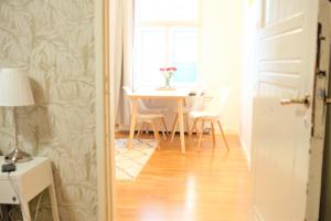 una sala da pranzo con tavolo, sedie e finestra di Stay Here Apartment Liisa a Helsinki