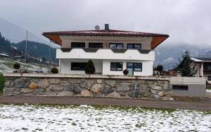 ein Haus auf einer Steinmauer in der Unterkunft Apart Troppmair in Aschau