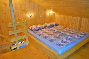Cama en habitación de madera con escalera en Sleeping with the bees Kozjak, en Kobarid
