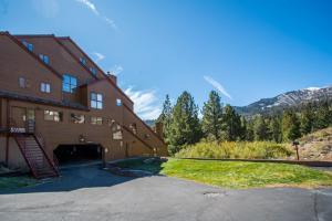 a building with a garage next to a mountain at Aspen Creek by 101 Great Escapes in Mammoth Lakes