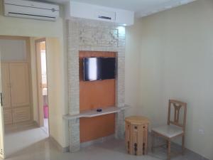 a living room with a tv on a wall at Résidence El Arich in Tozeur