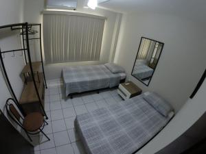 uma vista para um quarto com 2 camas e um espelho em Casa Área Central no Balneário Camboriú