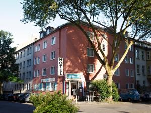 ein rotes Gebäude mit einem Schild, das das Hotel liest in der Unterkunft Stadt-gut-Hotel Rheinischer Hof in Essen