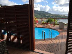 a view of a swimming pool from the balcony of a house at Gites La Nantillaise in Bouillante
