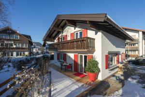 ein kleines Haus mit einem Balkon und einer Terrasse in der Unterkunft Chalet Alpin in Oberstdorf