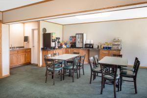 ein Esszimmer mit Tischen und Stühlen sowie eine Küche in der Unterkunft Days Inn by Wyndham Salem, Illinois in Salem