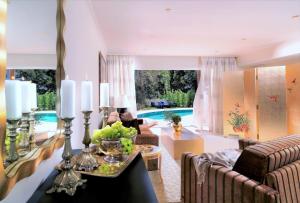 a living room with a pool in the background at Out Of The Blue Resort & Spa in Agia Pelagia