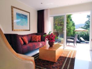 a living room with a red couch and a table at Out Of The Blue Resort & Spa in Agia Pelagia