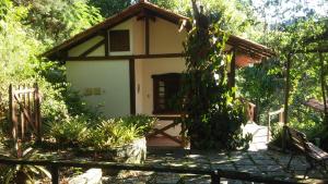 エンジェニェイロ・パウロ・デ・フロンチンにあるCheiro de Mata Pousada e Restaurante Ltdaの塀付きの庭の小屋