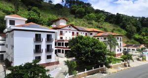 una fila de edificios blancos frente a una montaña en Hotel Recanto Bela Vista en Águas de Lindóia