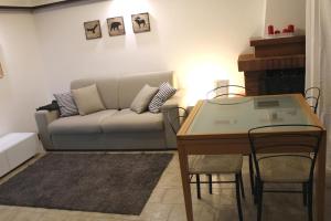un soggiorno con divano e tavolo di Trentino Apartments - Casa Corn a Folgaria