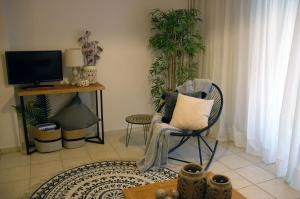 a living room with a chair and a tv at Acropolis, Urban Lifestyle apartment in Athens