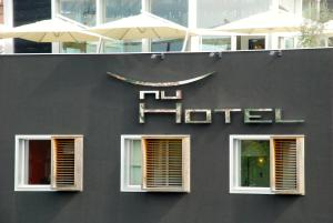 ein schwarzes Gebäude mit zwei Fenstern und einem Hotelschild in der Unterkunft Nu Hotel in Mailand