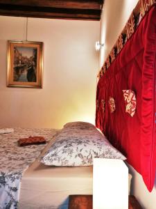 una camera con letto con testiera rossa di Apart 1531 a Venezia