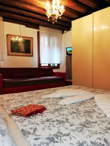 una camera da letto con un grande letto con un tovagliolo rosso sopra di Apart 1531 a Venezia