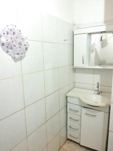 un bagno bianco con lavandino e specchio di DOÑA ROSA a Puerto Iguazú