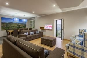 a living room with couches and a dining room at Feel Discovery Douro LAS House in Peso da Régua