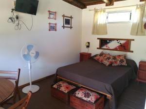 1 dormitorio con 1 cama y ventilador en Pequeñas Diablitas, en Punta del Diablo